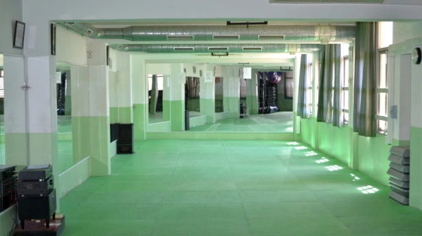 Sala de actividades con suelo verde y espejos